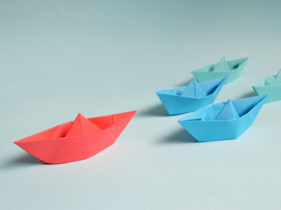 Image of paper origami boats with one out front