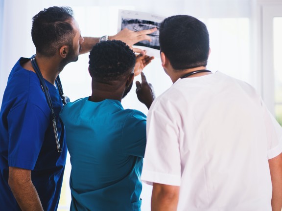 Three people looking at an x-ray result